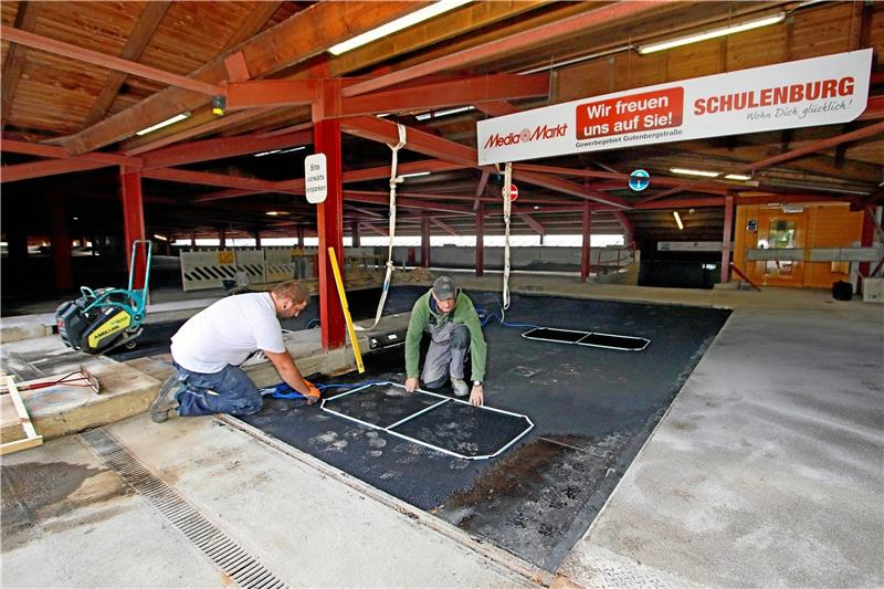 Bitumen aufgetragen und Induktionsschleifen gesetzt: Die Arbeiter legen letzte Hand bei den Sanierungsarbeiten im Parkhaus am Achtermann an.  Foto: Epping
