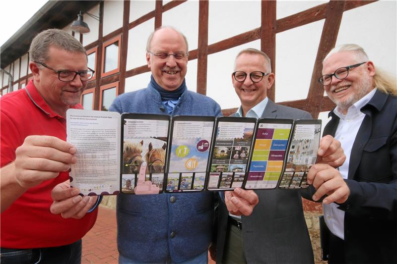 Blättern in einem Flyer in Smartphone-Optik zum Nördlichen Harzvorland (v.li.): Alf Hesse, Andreas Memmert und Dirk Neumann vom Vorstand des Tourismusverbands sowie Verbandsgeschäftsführer Björn Reckewell. Foto: Gereke