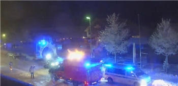 Polizei- und Feuerwehrfahrzeuge stehen auf der beschneiten Straße mit Blaulicht.