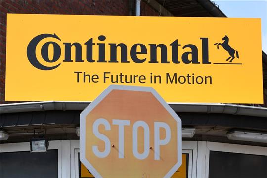 Blick auf das Logo des Reifenherstellers Continental und ein Stop-Schild.