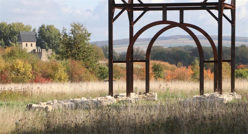 Was passierte im Mittelalter auf der Pfalz Werla? Blick auf das herbstliche Werla-Gelände: Durch die Stahlkonstruktion, die ein Tor der Vorburg andeutet, fällt der Blick auf den Großen Fallstein, links das rekonstruierte Westtor. Wie es hier wohl vor mehr als 1000 Jahren zuging?