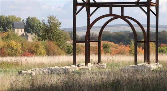 Blick auf das herbstliche Werla-Gelände: Durch die Stahlkonstruktion, die ein Tor der Vorburg andeutet, fällt der Blick auf den Großen Fallstein, links das rekonstruierte Westtor. Wie es hier wohl vor mehr als 1000 Jahren zuging?