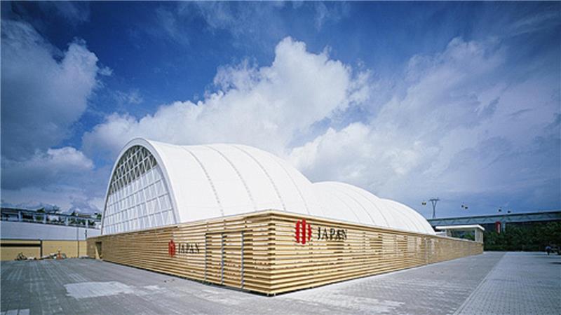 Das Foto zeigt den Japanischen Pavillion bei der Expo 2000 in Hannover. Das Dach besteht aus einer halbrunden Metallkonstruktion, die weiß bespannt ist.