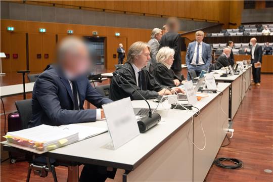 Blick auf die Anklagebank mit Angeklagten (gepixelt) und Verteidigern in der Stadthalle Braunschweig. Vier ehemalige VW-Manager sind unter anderem wegen beandenmäßigen Betrigs angeklagt. Foto: Julian Stratenschulte/dpa