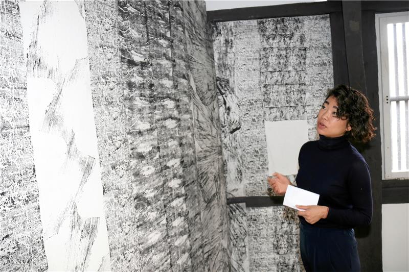 Natur und Kunst: Ausstellung im Goslarer Mönchehaus Blick auf eine Borkenkäfertapete: Die Künstlerin Jeewi Lee vor einem Objekt, das während eines Workshops von „Wald für morgen“ entstand. Foto: Hartmann