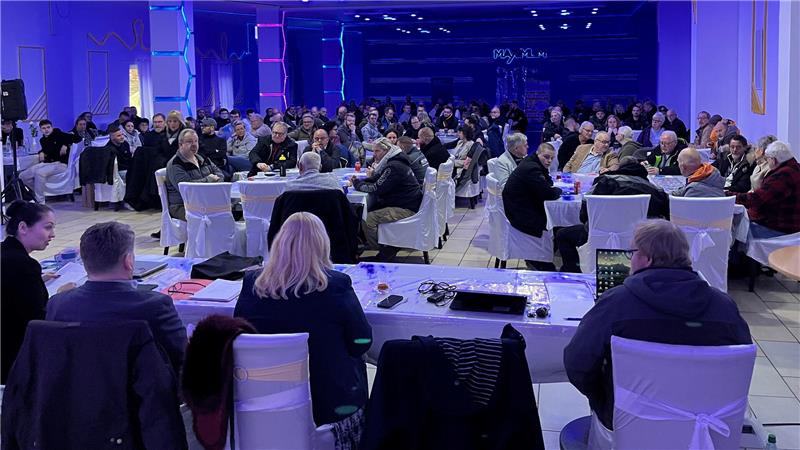 Blick in einen Versammlungsraum mit vielen Menschen.