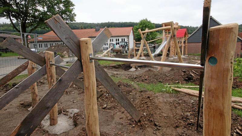 Blick über die Spielgeräte in Richtung Dorfgemeinschaftshaus: Das für die Herstellung der Geräte verwendete Holz stammt von Robinien.