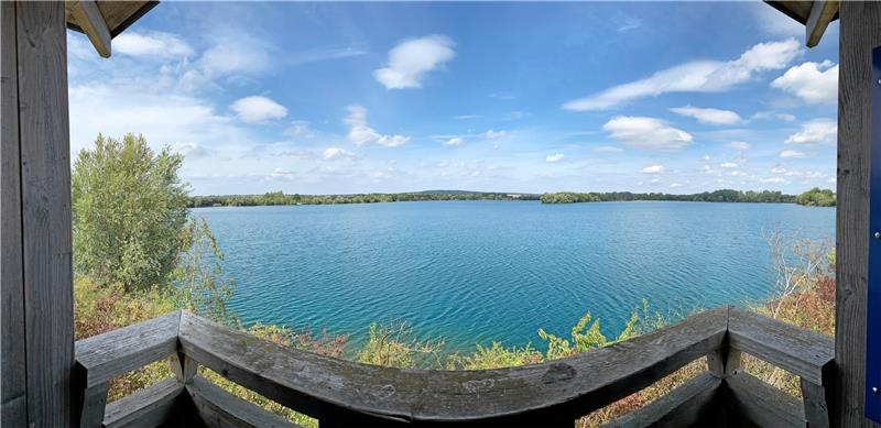 Blick vom Vogelbeobachtungsturm auf den Kiesteich. Die Panoramafunktion der Kamera lässt den geraden Balken im Vordergrund geschwungen erscheinen – die gute Wasserqualität lässt sich allerdings nur erahnen. Fotos: Gereke, dpa, Fischereiverein