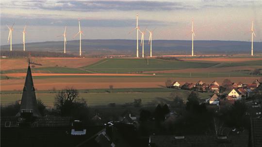Blick von der Sängerlaube: Im Hintergrund leuchten die Windenergieanlagen zwischen Schladen, Beuchte und Wehre, im Vordergrund liegt Döhren im Schatten des Höhenzugs. Im Dreieck Döhren, Neuenkirchen, Liebenburg sollen weitere Windräder entstehen.