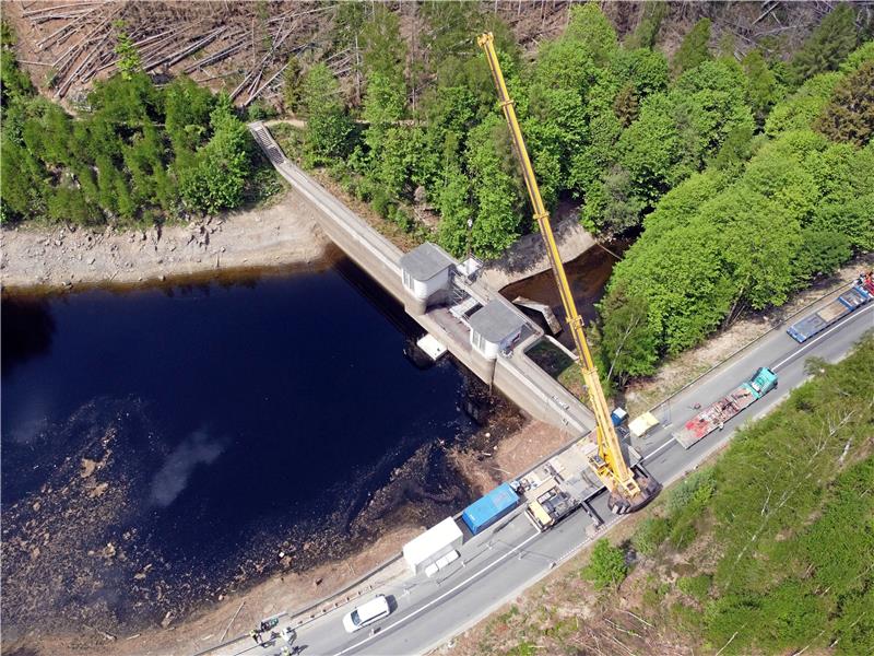 Okertalsperre: 12,5 Tonnen schwere Wehrklappe hängt am Kran Blick von oben auf die Baustelle: Der Kran-Arm ragt weit über die Wasserfläche und angelt nach der Wehrklappe. Fotos: Neuendorf