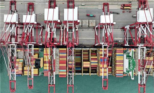 Blick von oben auf ein Containerschiff im Hafen von Qingdao in der ostchinesischen Provinz Shandong.