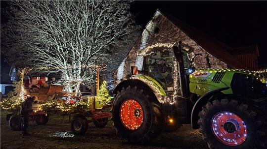 Blickfang für viele Zuschauer an den Straßen: Die weihnachtlich geschmückten Trecker bringen Licht in die Dunkelheit.