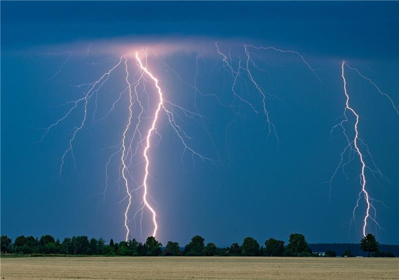 Wochenende zeigt wenig Anzeichen von Hochsommer Blitze eines Gewitters leuchten am Abendhimmel im Osten des Landes Brandenburg.