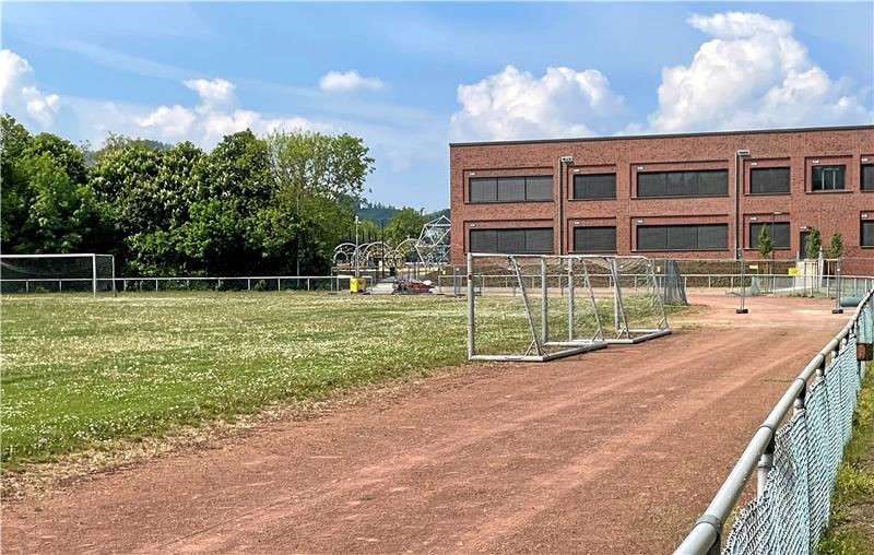 Blümchenwiese mit Uralt-Laufbahn: Während sich im Hintergrund das neue Schulzentrum bautechnisch kurz vor dem Zieleinlauf befindet, ist die Sportanlage an der Goldenen Aue in die Jahre gekommen. Fotos: Heine (2), Roß