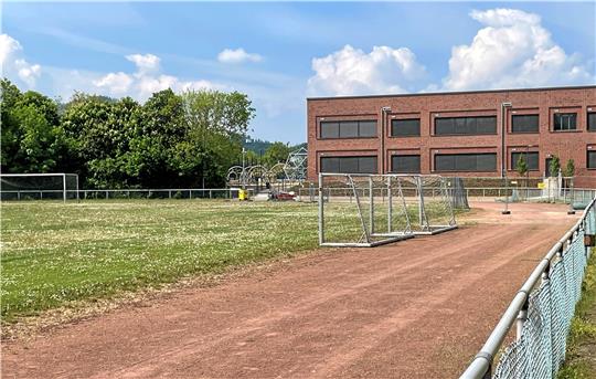 Blümchenwiese mit Uralt-Laufbahn: Während sich im Hintergrund das neue Schulzentrum bautechnisch kurz vor dem Zieleinlauf befindet, ist die Sportanlage an der Goldenen Aue in die Jahre gekommen. Fotos: Heine (2), Roß
