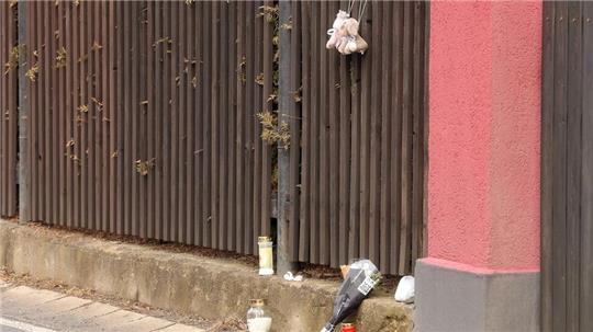 Blumen, Kerzen und Plüschtiere sind an einem Gartenzaun in Neumark niedergelegt. Im Ortsteil soll ein Vater erst seine beiden Kinder, dann sich selbst getötet haben. 
