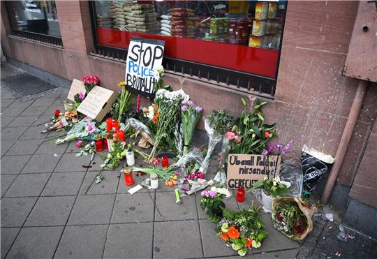 Blumen, Kerzen und Schilder liegen an dem Ort, an dem ein Mann Anfang Mai 2022 nach einer Polizeikontrolle gestorben ist.
