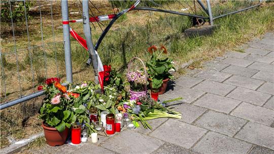 Blumen liegen am Tatort in Varel im Landkreis Friesland (Archivfoto). Der Prozess um einen mutmaßlich heimtückischen Mord mit einem Auto im Landkreis Friesland hat begonnen.