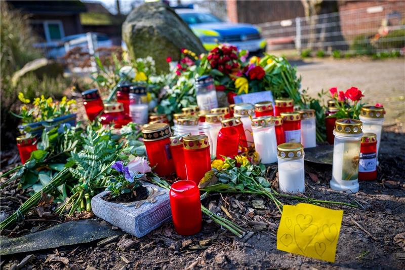 Gedenken an die vier Opfer der tödlichen Schüsse Blumen und Kerzen liegen vor einem Einfamilienhaus in Scheeßel.