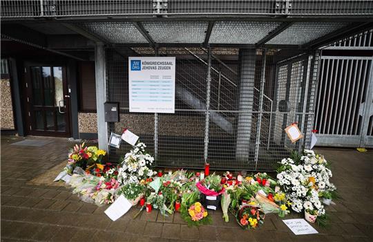Blumen und Kerzen vor dem Eingangsbereich des Gemeindehauses der Zeugen Jehovas.