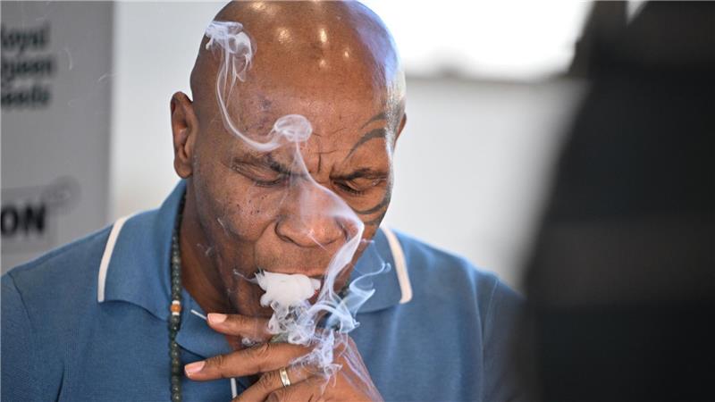 Box-Ikone Mike Tyson kifft in Berlin Box-Ikone und Cannabis-Unternehmer Mike Tyson raucht an einem Stand der Cannabis-Messe Mary Jane einen Joint.