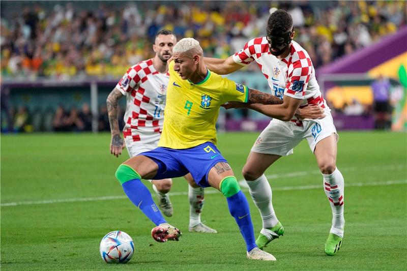 Neymar und Brasilien am Boden: Kroatien stoppt Seleção Brasiliens Richarlison (M) schirmt den Ball vor dem Kroaten Josko Gvardiol (r) ab.