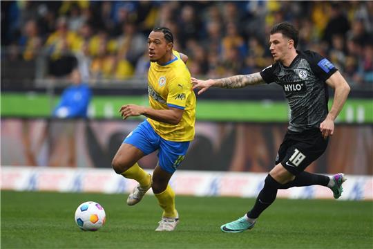 Braunschweigs Anton Donkor (l) spielt gegen Elversbergs Hugo Vandermersch. Zur neuen Saison wechselt Donkor zum FC Schalke.