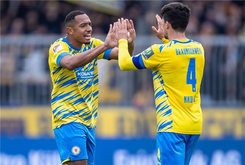 Braunschweigs Anton Donkor (l) und Braunschweigs Jannis Nikolaou freuen sich über den 2:1 Sieg gegen Sandhausen.
