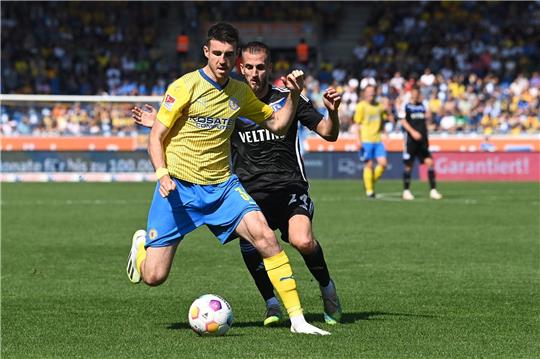 Braunschweigs Kaan Caliskaner (l) spielt gegen Schalkes Dominick Drexler.