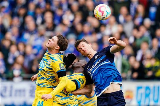Braunschweigs Linus Gechter (l-r), Braunschweigs Tarsis Bonga und Darmstadts Christoph Zimmermann kämpfen um den Ball.