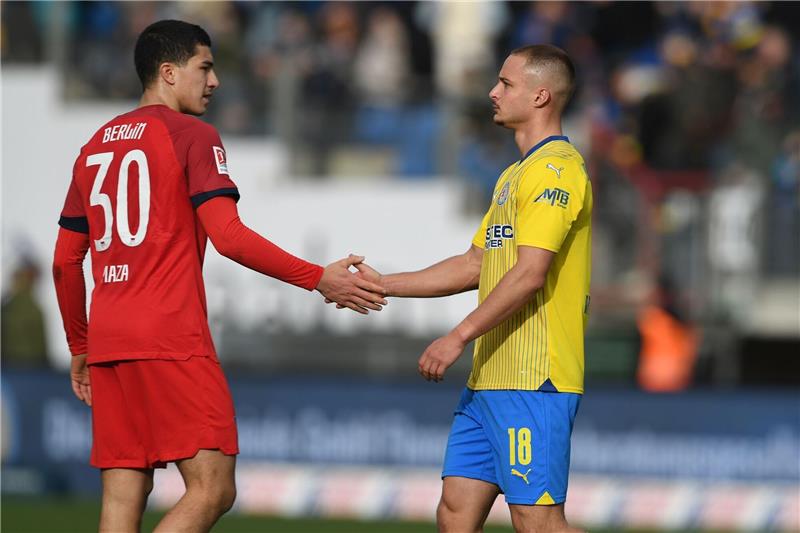 Braunschweigs Marvin Rittmüller (r) und der Berliner Ibrahim Maza klatschen sich nach dem 1:1 ab.