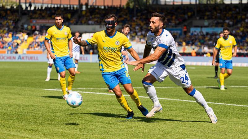 Braunschweigs Robin Krauße (l) in Aktion gegen Karlsruhes Fabian Schleusener.