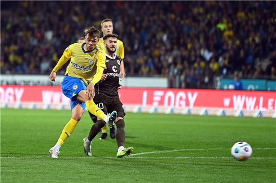 Braunschweigs Thorir Holgason (l) erzielt gegen St. Paulis Marcel Hartel den Treffer zum 1:1.