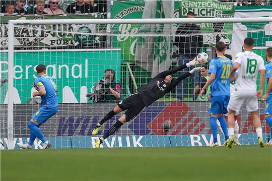 Braunschweigs Torwart Ron Torben Hoffmann (M) kann einen Schuss mit den Fingerspitzen klären.