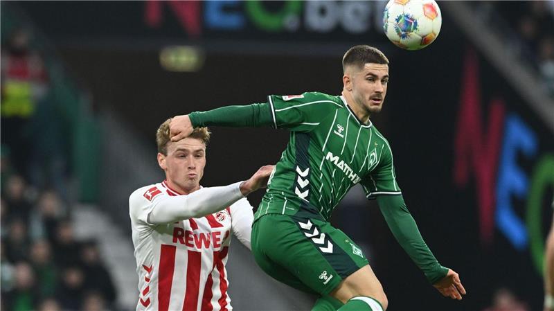 Bremens Romano Schmid (r) geht artistisch zum Ball, der Kölner Sebastian Sebulonsen schaut gebannt zu.