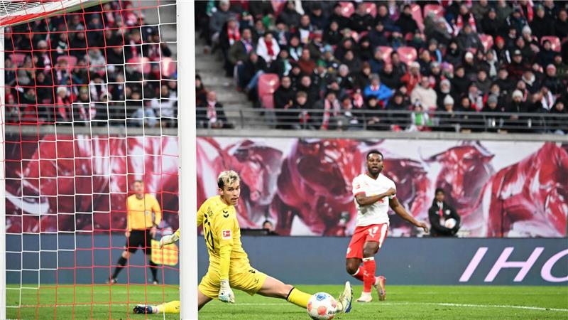 Bremens Torwart Mio Backhaus (l, Werder Bremen) und Ridle Baku (RB Leipzig) schauen dem Ball hinterher. Backhaus verhinderte mit seinen Paraden einen frühen Rückstand der Gäste in Leipzig.