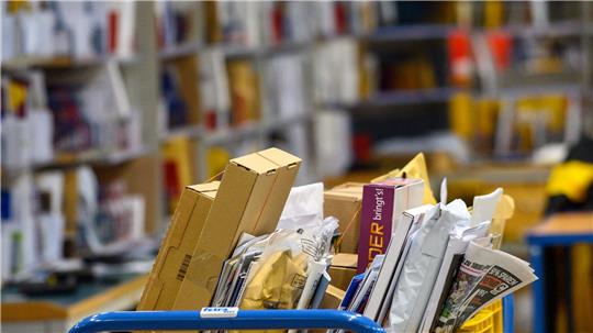 Briefe und Päckchen liegen in einem Zustellstützpunkt der Post - zuletzt transportierte der Postdienstleister mehr Briefe als gedacht. (Archivbild)