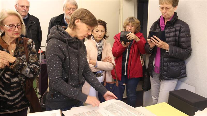 Buch-Restauratorin Katharina Lußky zeigt, wie sie herausgetrennte Seiten wieder in die alten Bücher einfügt.