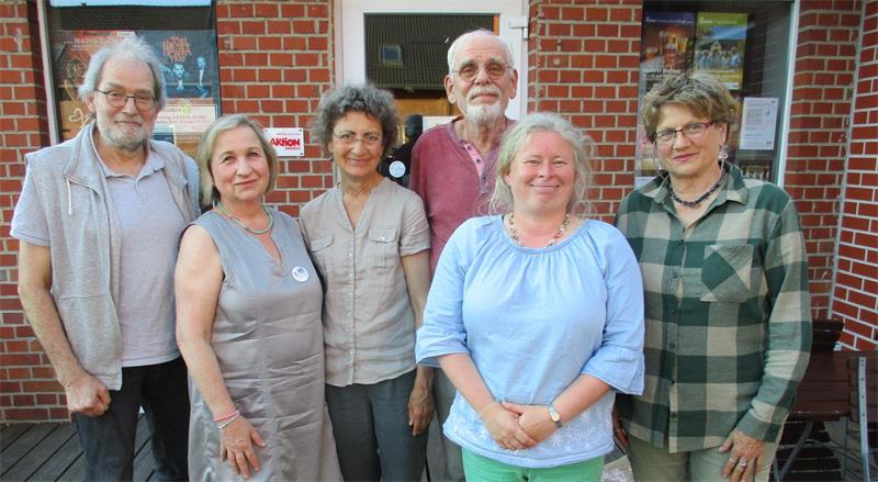 Sechs Frauen und Männer stehen nebeneinander und posieren für ein Foto.