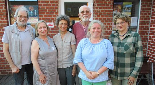 Sechs Frauen und Männer stehen nebeneinander und posieren für ein Foto.