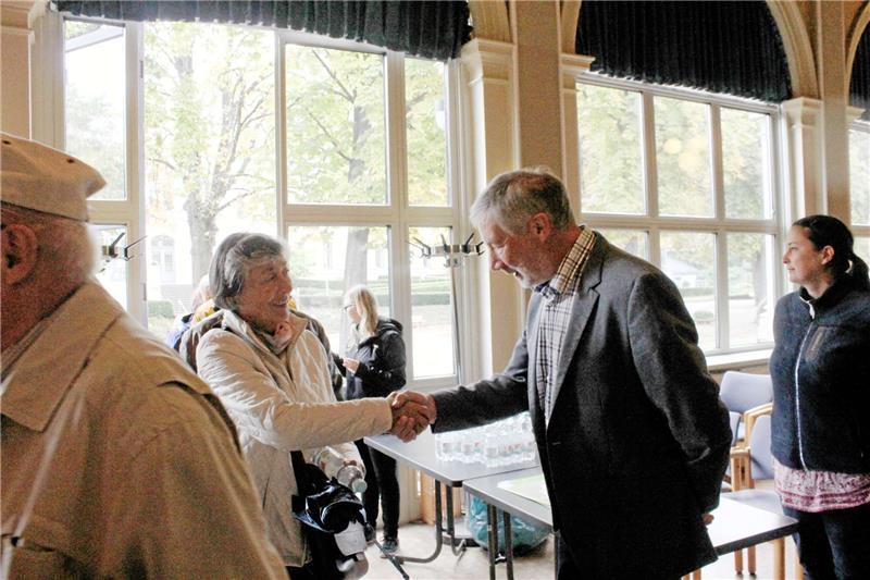 Bürgermeister Abrahms begrüßte mit Handschlag. Edda Schaper (rechts) hatte die Gäste mit dem Bus abgeholt.