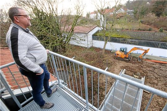 Bürgermeister Alf Hesse blickt vom Rathausbalkon in seine Gemeinde: Unten ist das Podest zu erkennen, von dem aus die Feuerwehr im Rettungsfall die Leiter anstellen kann. Dahinter steht der Bagger, der noch das Umfeld anpassen wird. Foto: Gereke