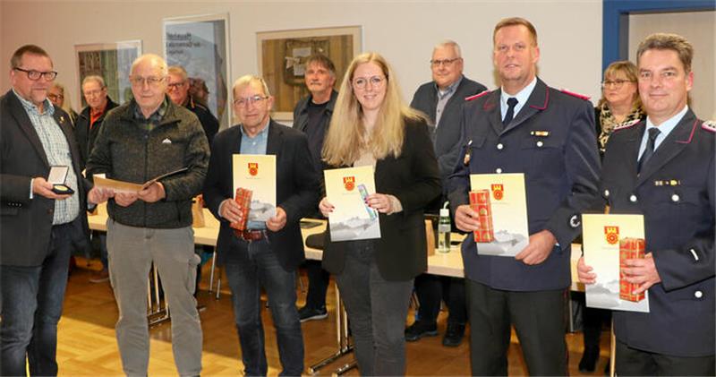 Bürgermeister Alf Hesse (l.) zeichnet langjährige ehrenamtlich Tätige aus (v.l.): Wolfgang Fricke, Günther Meyer, Sarah Schreiber, Oliver Bormann und Dennis Quadt. Für die Ehrung erheben sich die Ratsmitglieder von ihren Plätzen (Hintergrund).