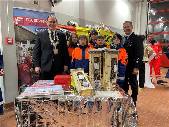Bürgermeister Ingo Henze (links) und Ortsbrandmeister Hartmut Ölmann mit dem Feuerwehrnachwuchs. Foto: Heine
