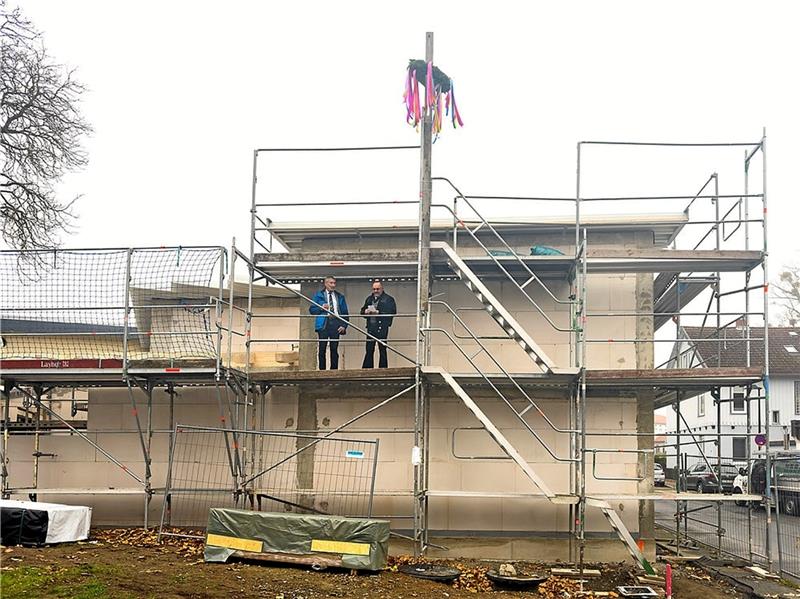 Bürgermeister Ralf Abrahms (l.) und Zimmermeister Thomas Krause sind für den Richtspruch aufs Gerüst geklettert. Foto: Feuerwehr
