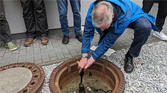 Bürgermeister Ralf Abrahms schmiert im Beisein der Harlingeroder Honoratioren die Erdachse ab.