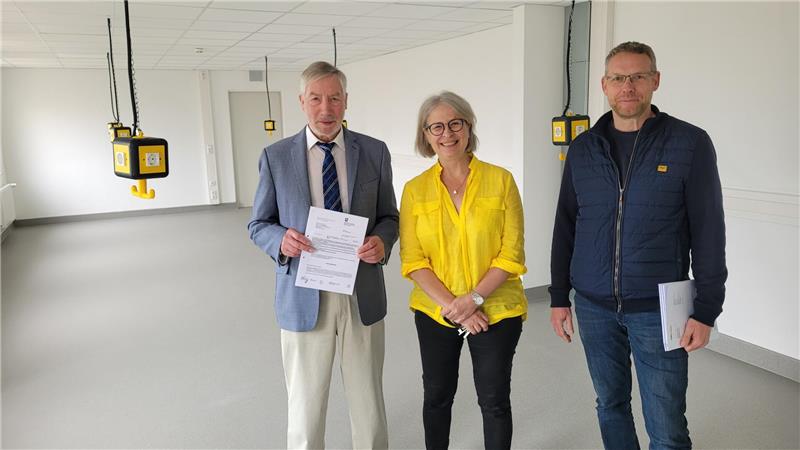 GHS: So schick sieht Bad Harzburgs neue Ganztagsschule aus Bürgermeister Ralf Abrahms und Hochbauingenieur Martin Etscheid bringen Schulleiterin Tamara Pietscher den Förderbescheid des Landes Niedersachsen mit. Im Hintergrund ist der neue Werkraum zu sehen, früher Mädchenumkleide.