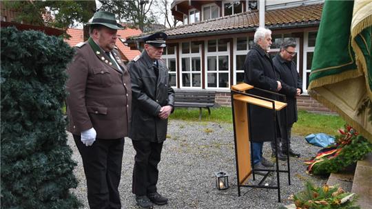 Bürgermeister Wolfgang Langer, Ortsvorsteher Albert Baumann, Stadtbrandmeister Hans Ervenich und Schützen-Vorsitzender Matthias Schmidt legen am Ehren- und Mahnmal am Kurpark Kränze nieder.