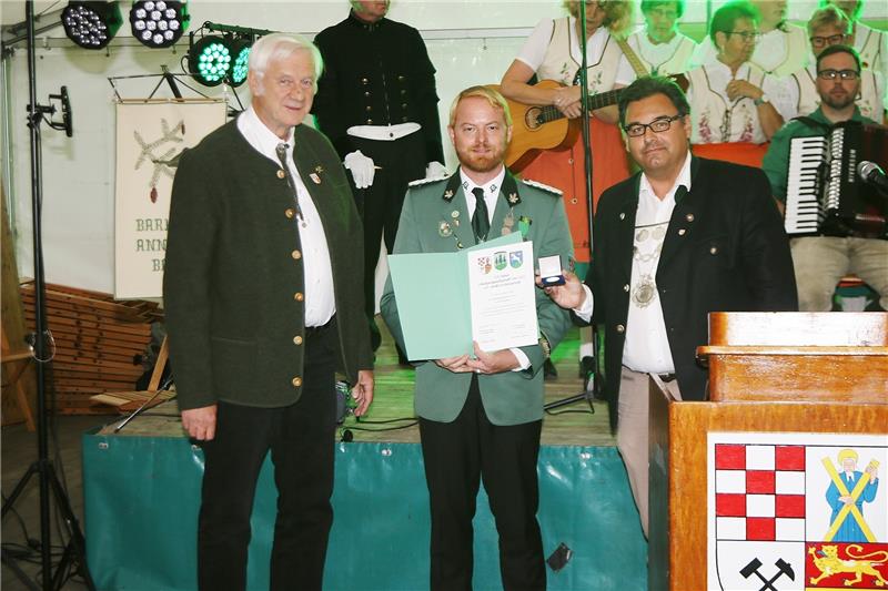 St. Andreasberger Schützen feiern Geburtstag Bürgermeister Wolfgang Langer (re) und Ortsvorsteher Karl-Heinz Plosteiner (li) überreichen Schützenvogt Frederik Kunze die Auszeichnung