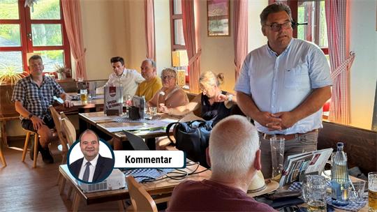 Mehrere Menschen sitzen in einem Raum voller Tische.